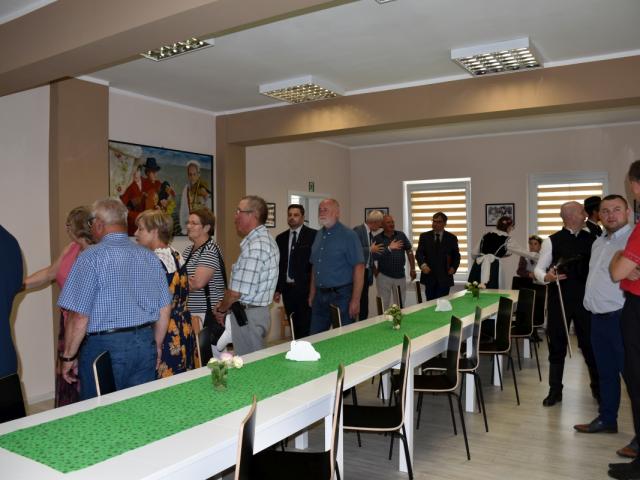 Uczestnicy wydarzenia podziwiający stałą wystawę zdjęć zgromadzoną w Gminnym Centrum Kultury w Bukówcu Górnym