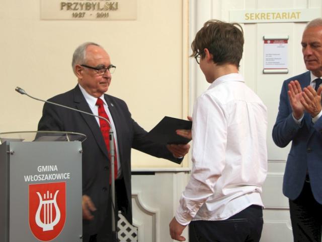 Profesor Krzysztof Sperski wręcza dyplom laureatowi konkursu, obok stoi wójt gminy Włoszakowice Robert Kasperczak