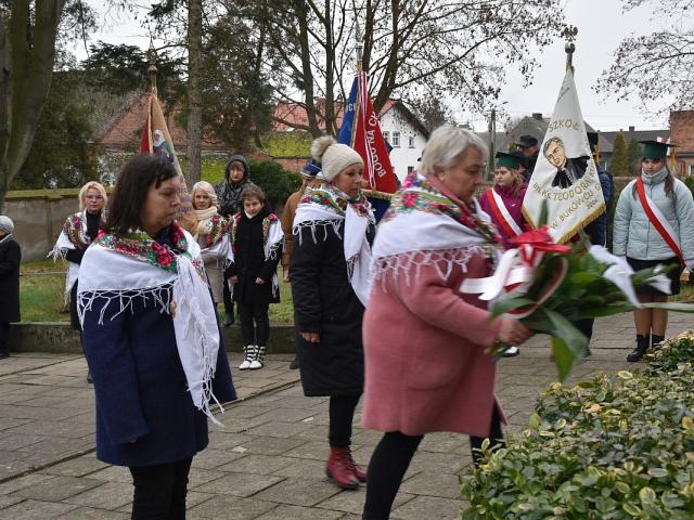 Delegacja Koła Gospodyń Wiejskich w Bukówcu Górnym składa wiązankę kwiatów przy tablicach pamiątkowych