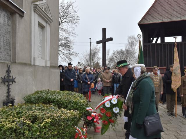 Delegacja Zespołu Regionalnego im. Anny Markiewicz w Bukówcu Górnym składa wiązankę kwiatów przy tablicach pamiątkowych