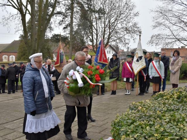 Delegacja składa wiązankę kwiatów przy tablicach pamiątkowych