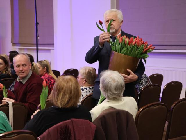 Przewodniczący Rady Gminy Włoszakowice Kazimierz Kurpisz wręcza tulipany obecnym kobietom