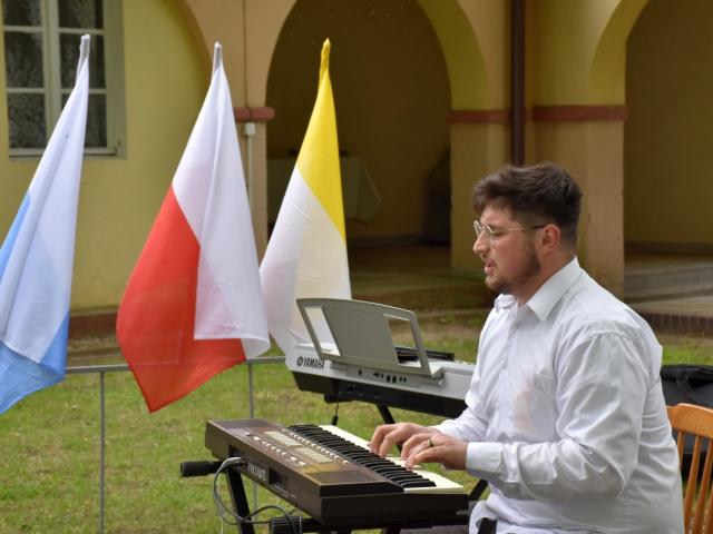 Instruktor Rafał Grygiel gra na pianinie