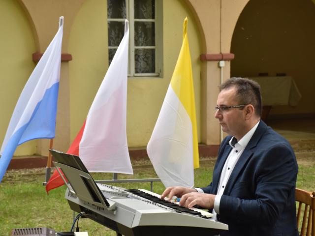 Instruktor Mariusz Lorych gra na pianinie
