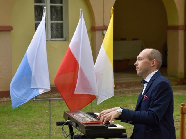 Instruktor Mariusz Kowalczyk gra na pianinie