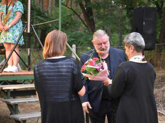 Uczestniczki spotkania wręczają kwiaty Markowi Prałatowi