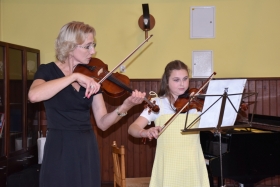 Instruktor Anna Grochowczak i uczennica Ogniska Julia Nowaczyk grające na skrzypcach