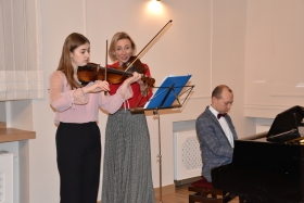 Uczennica ogniska i instruktorka Anna Grochowczak grają na skrzypcach, Mariusz Kowalczyk gra na fortepianie