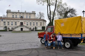 Uczestnicy rajdu przy swoim pojeździe, w tle Pałac Sułkowskich