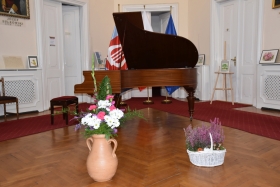 Kwiaty stoją przed fortepianem
